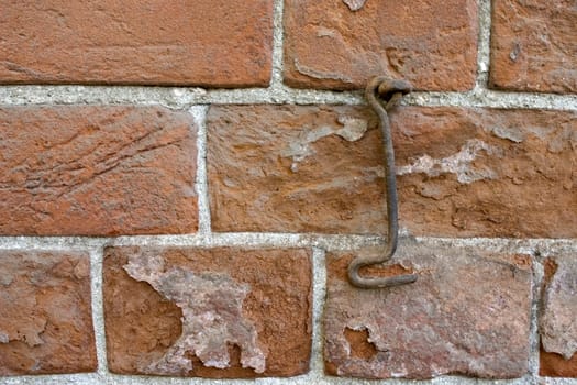 Brick wall and old metal hook.