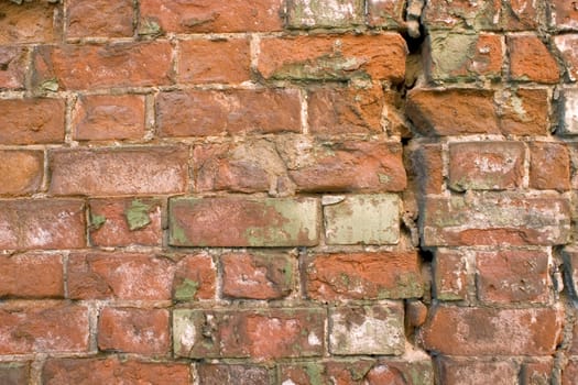 The damaged brick wall.