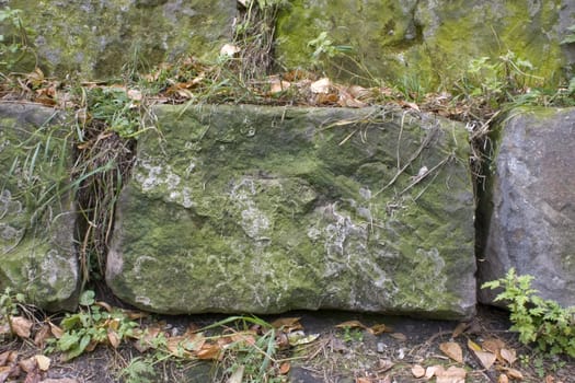Stone wall, green grass, yellow sheet.
