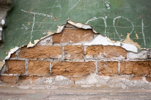 Old wall from a red brick. Green paint.