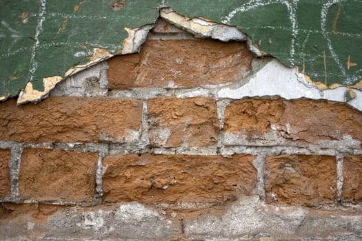Old wall from a red brick. Green paint.