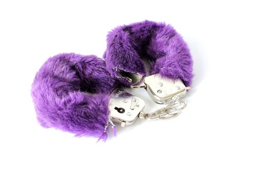 Isolated purple fuzzy cuffs used for adult entertainment.