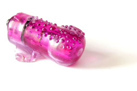 Isolated pink finger vibrator used for adult entertainment.
