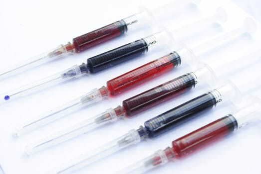 Medical syringes with colorful liquid isolated over white