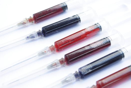 Medical syringes with colorful liquid isolated over white