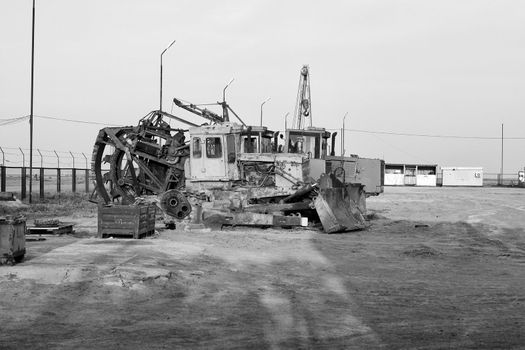 Monochrome black and white imager of a backhoe and digger at a construction site involving earth moving and excavation