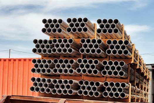 Aluminium tubes arranged in a row against the blue sky.