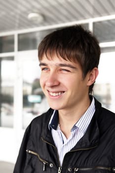 portrait of smiling teenager outdoor near the glass building