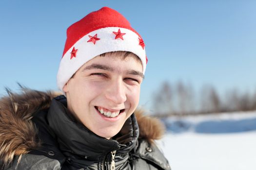 happy young man in santa's hat outdoor in the winter