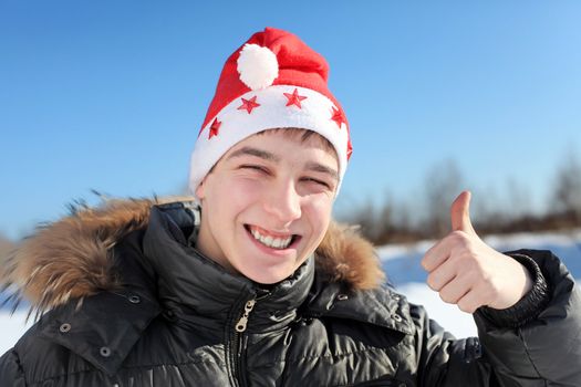 happy young man in santa's hat outdoor in the winter