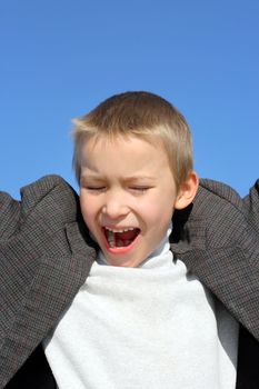 screaming boy on the blue sky background