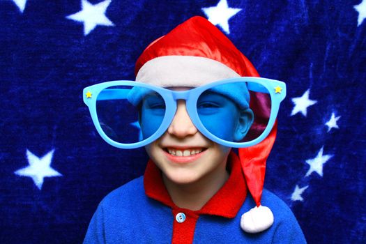 Small Boy in Big blue Glasses on the Blue Curtain background