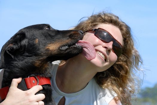 portrait of a purebred french sheepdog beauceron and smiling woman