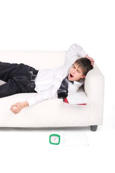 Student waking up on the Sofa with the Books and Alarm Clock. Isolated on the white