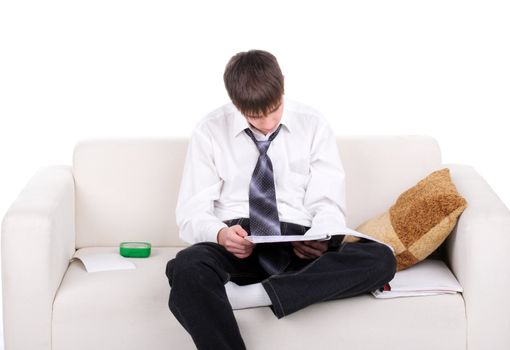 Teenager reads the book on the Sofa. Isolated on the white