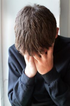 Sorrowful Teenager hide his face