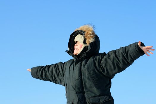 Happy Boy in the Winter on the Blue Sky background