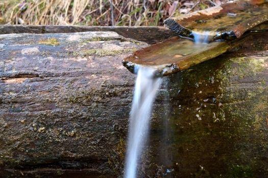 wooden channel for water at a spring in the mountains