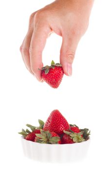 Hand taking strawberry out of bowl