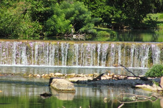 Man made waterfall over concrete wall.