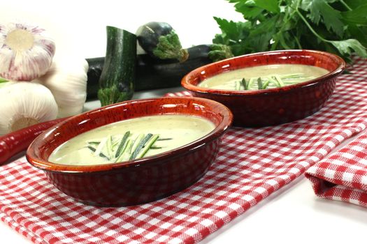 fresh creamy zucchini soup in bowls on a red napkin