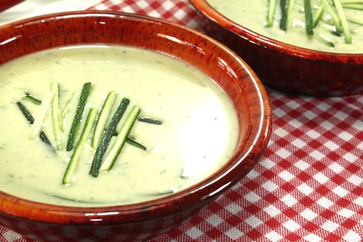 fresh zucchini cream soup in bowls on a checkered napkin