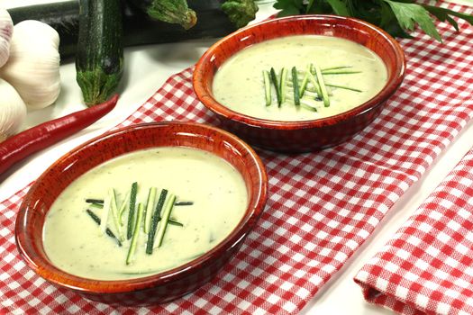 fresh zucchini cream soup in bowls on a red and white checkered napkin