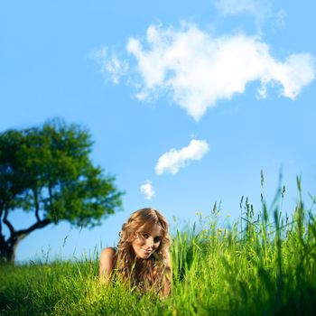 blonde lays under the tree 