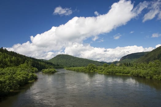 Summer. A river landscape with clouds.