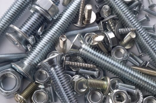 The large and small bolts and screws on a white background.
