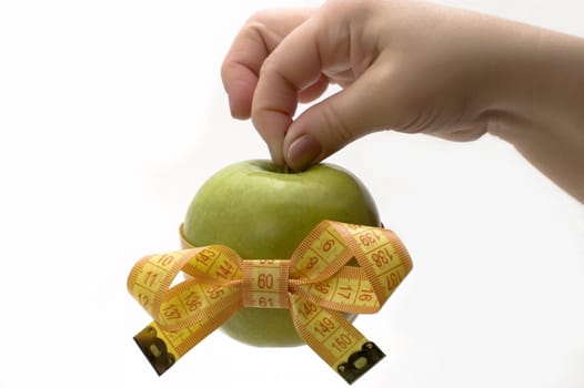 Green apple with measuring tape in a hand.