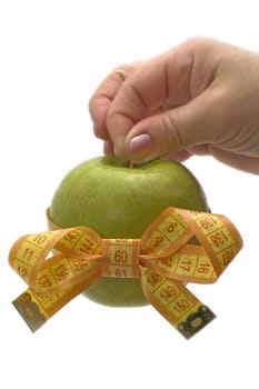 Green apple with measuring tape in a hand.