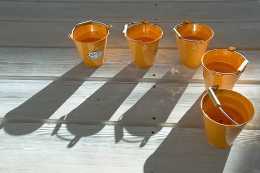 Orange utensils, shadow on a floor.