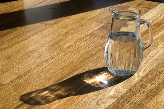 Decanter with water on a wooden floor.