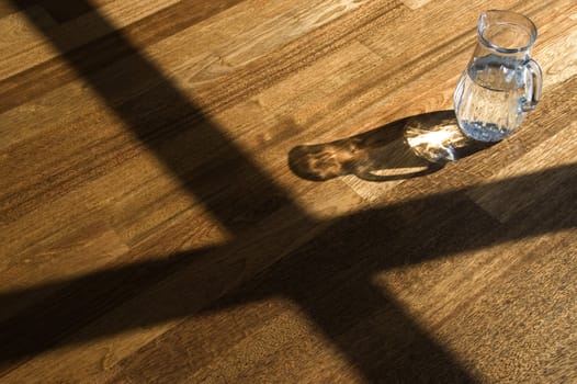 Decanter with water on a wooden floor.