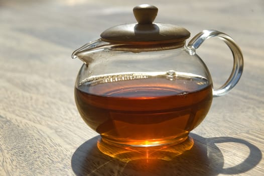 Transparent cup of tea on a wooden floor.
