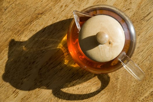 Transparent cup of tea on a wooden floor.