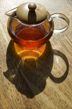 Transparent cup of tea on a wooden floor.
