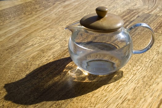 Transparent cup with water on a wooden floor.