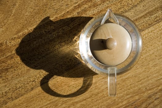 Transparent cup with water on a wooden floor.