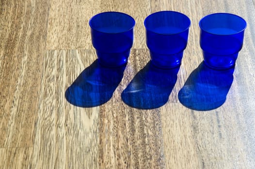 Dark blue utensils, shadow on a floor.