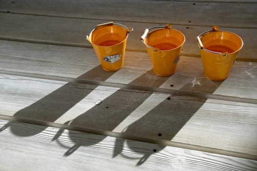 Orange utensils, shadow on a floor.