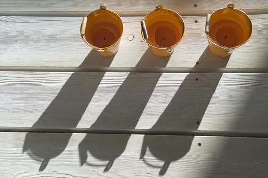 Orange utensils, shadow on a floor.