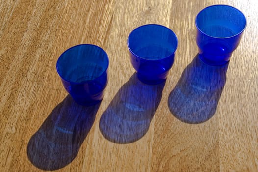 Dark blue utensils, shadow on a floor.