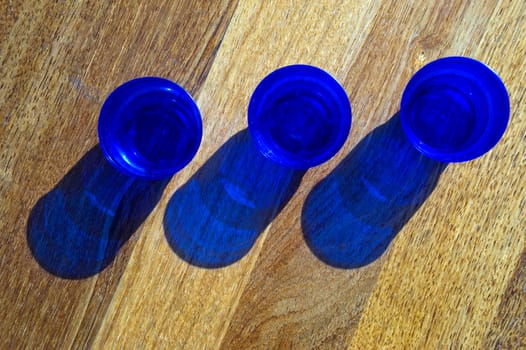 Dark blue utensils, shadow on a floor.