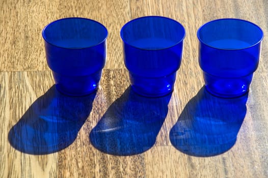 Dark blue utensils, shadow on a floor.