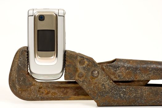 Old rusty nut key and modern telephone on a white background.