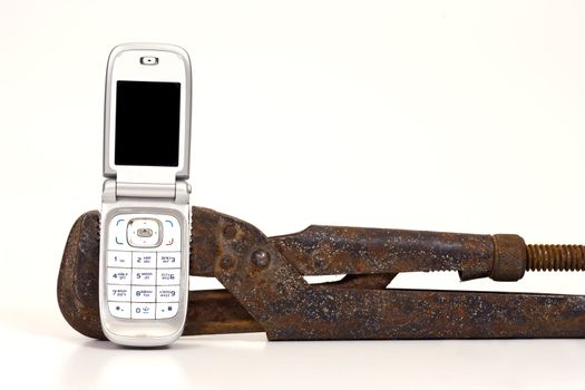 Old rusty nut key and modern telephone on a white background.