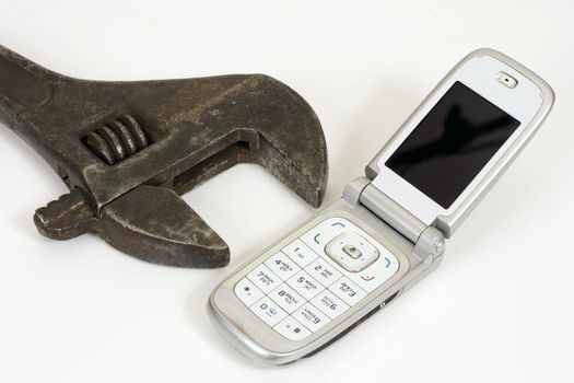 Old spanner and modern telephone.