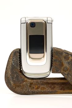 Old rusty spanner and modern telephone.